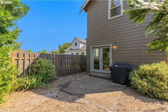 view of patio / terrace featuring a grill, a fenced backyard, and french doors