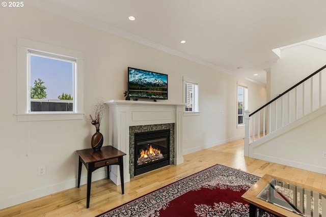 living area featuring stairs, baseboards, hardwood / wood-style flooring, and crown molding