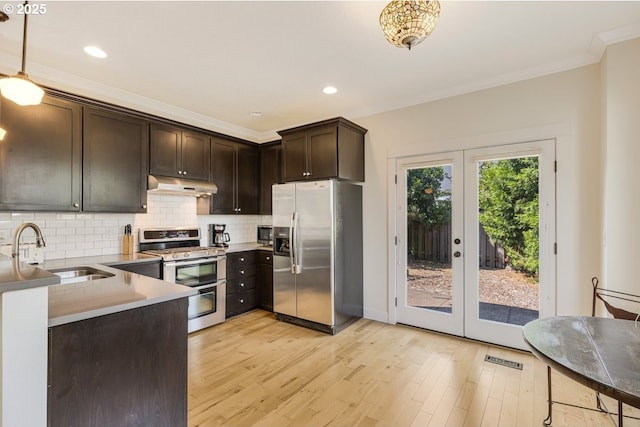 kitchen featuring stainless steel appliances, decorative backsplash, dark brown cabinetry, a sink, and under cabinet range hood