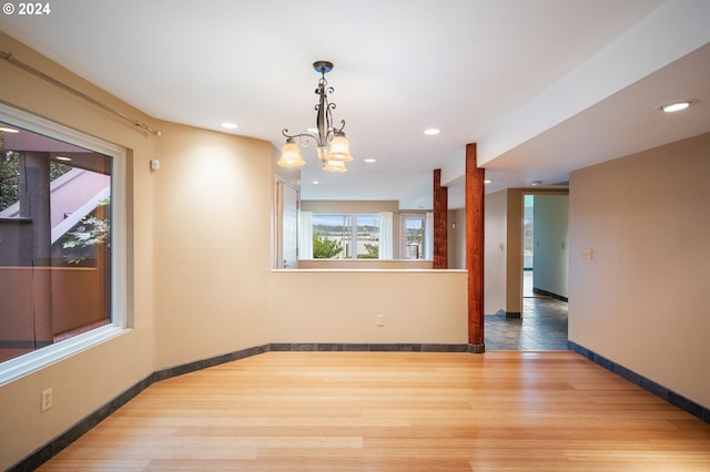 unfurnished room with wood-type flooring and a chandelier