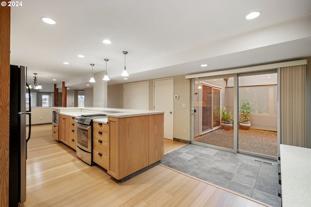 kitchen with light wood-type flooring, a spacious island, stainless steel appliances, pendant lighting, and an inviting chandelier