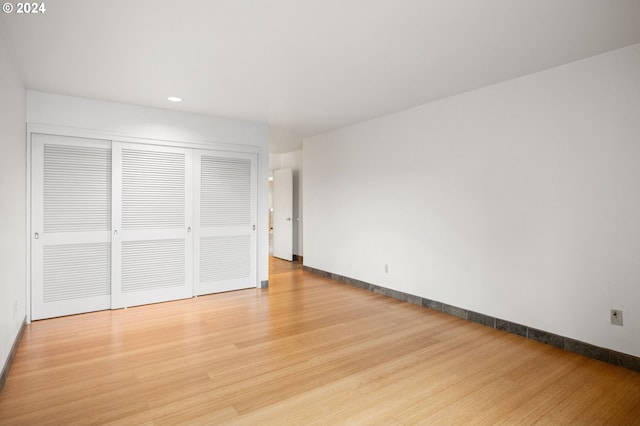 unfurnished bedroom featuring light hardwood / wood-style flooring and a closet