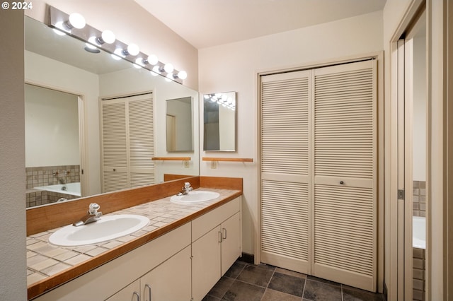 549 N Tomahawk Island Dr # 1, Portland, OR 97217 - bathroom featuring double vanity, a closet, a garden tub, and a sink