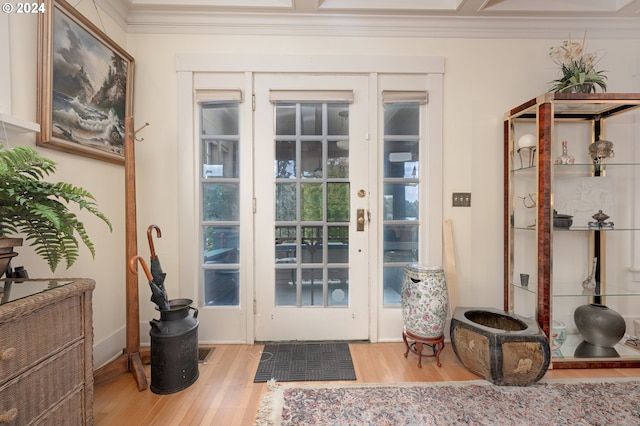 doorway with ornamental molding and light wood finished floors