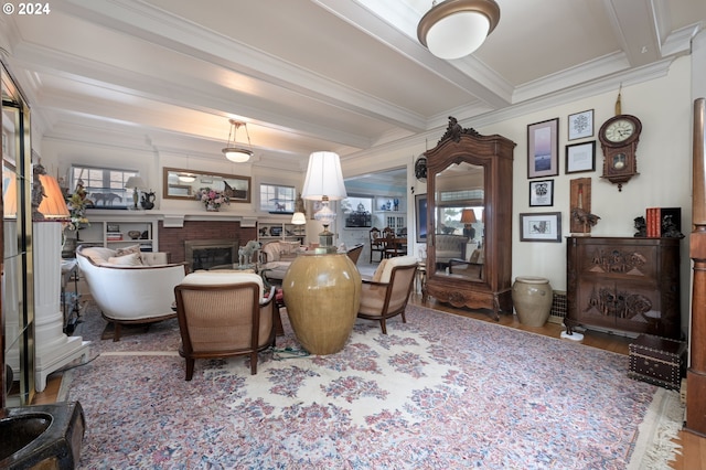 dining space with plenty of natural light, wood finished floors, beam ceiling, and a brick fireplace