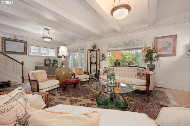 living area with beam ceiling, crown molding, wood finished floors, baseboards, and stairs