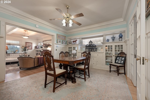 dining area with crown molding, light wood-style flooring, and ceiling fan