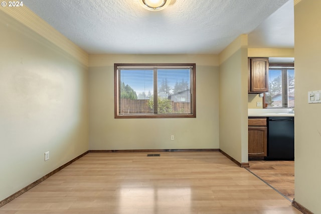 unfurnished dining area with a textured ceiling and light hardwood / wood-style flooring