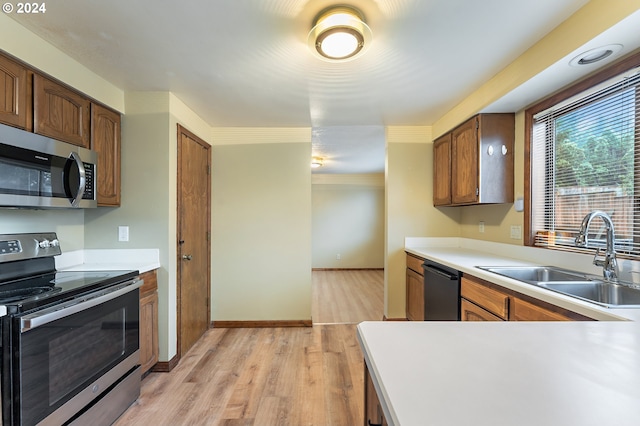 kitchen featuring appliances with stainless steel finishes, light hardwood / wood-style floors, and sink