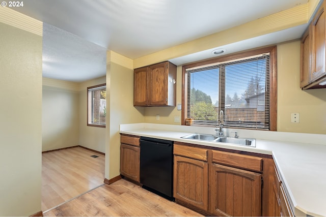 kitchen featuring plenty of natural light, sink, light wood-type flooring, and black dishwasher