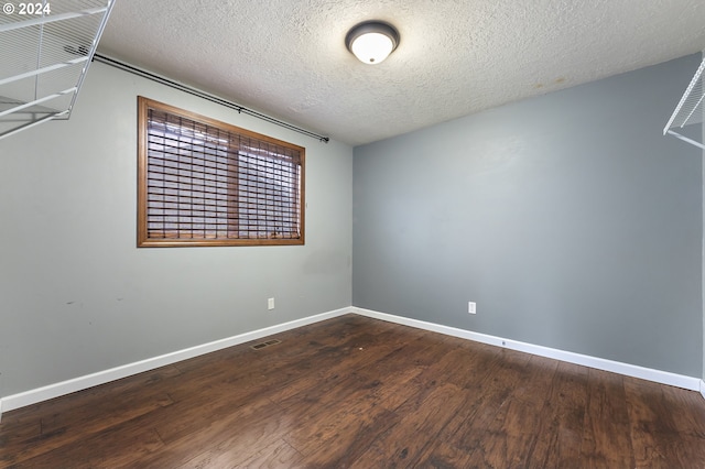 spare room with hardwood / wood-style floors and a textured ceiling