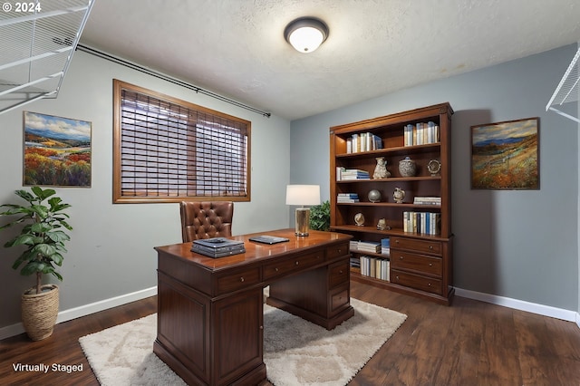 home office featuring dark wood-type flooring and a textured ceiling