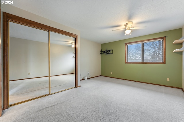 carpeted spare room with a textured ceiling and ceiling fan