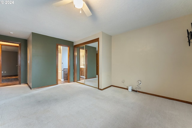 carpeted spare room featuring ceiling fan and a textured ceiling