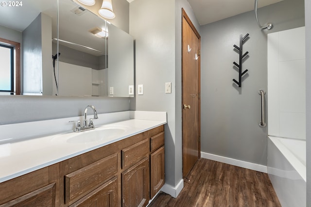 bathroom featuring vanity, wood-type flooring, and tub / shower combination