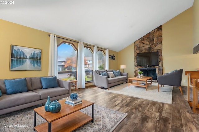 living room featuring a fireplace, high vaulted ceiling, and hardwood / wood-style flooring