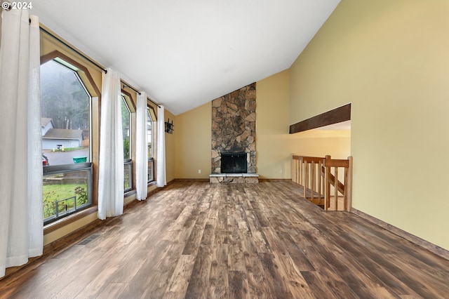 unfurnished living room featuring a wealth of natural light, a fireplace, high vaulted ceiling, and wood-type flooring