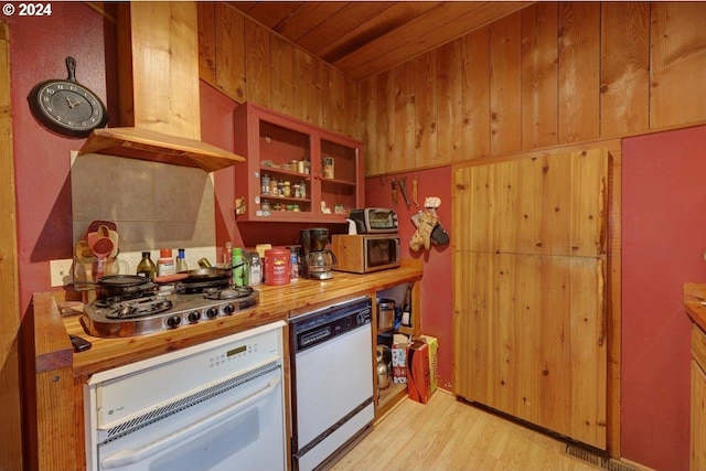 kitchen with butcher block counters, wood ceiling, light wood-type flooring, wooden walls, and white appliances