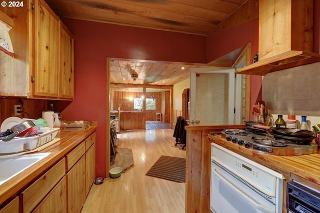 kitchen with stainless steel gas stovetop, sink, wood ceiling, white oven, and light hardwood / wood-style flooring