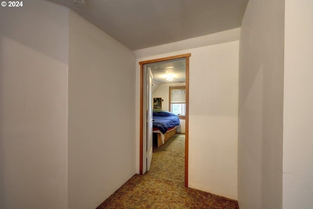 hall featuring vaulted ceiling and carpet