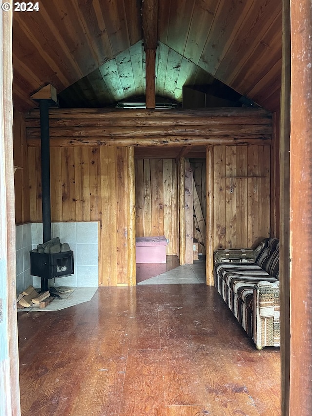 basement with wooden walls, wooden ceiling, and a wood stove