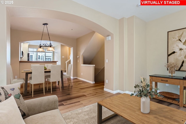 living room featuring a chandelier and light hardwood / wood-style flooring