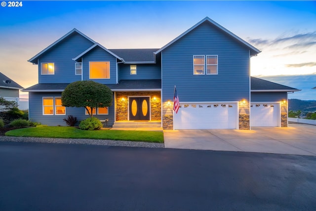 traditional home featuring stone siding, an attached garage, and concrete driveway