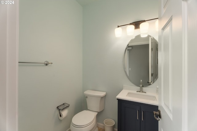 bathroom with toilet, baseboards, and vanity