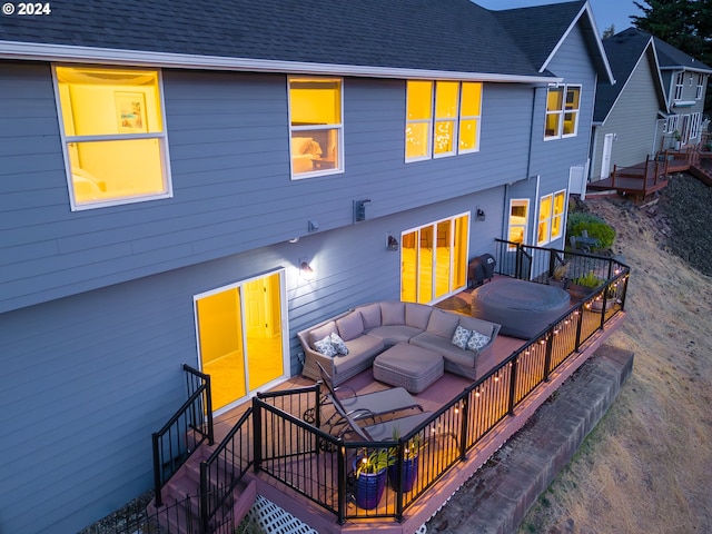 back of house with a deck, a shingled roof, outdoor lounge area, and a hot tub