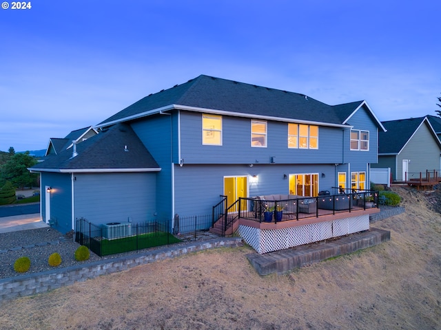 back of property with fence and a wooden deck