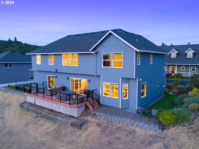 rear view of property featuring a deck and a shingled roof