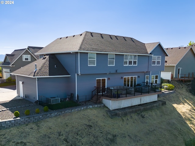 back of property with roof with shingles and a lawn