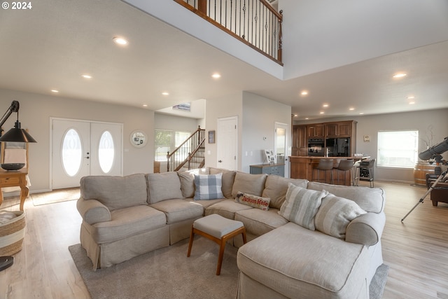 living area featuring recessed lighting, baseboards, stairway, and light wood finished floors