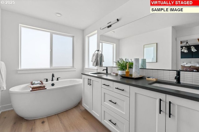 3825 S Arwana Ln, Ridgefield, WA 98642 - full bath with double vanity, a soaking tub, healthy amount of natural light, and wood finished floors