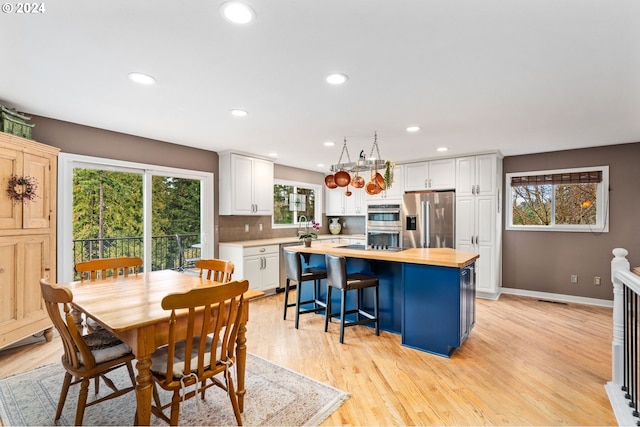 dining space with light hardwood / wood-style floors and a wealth of natural light