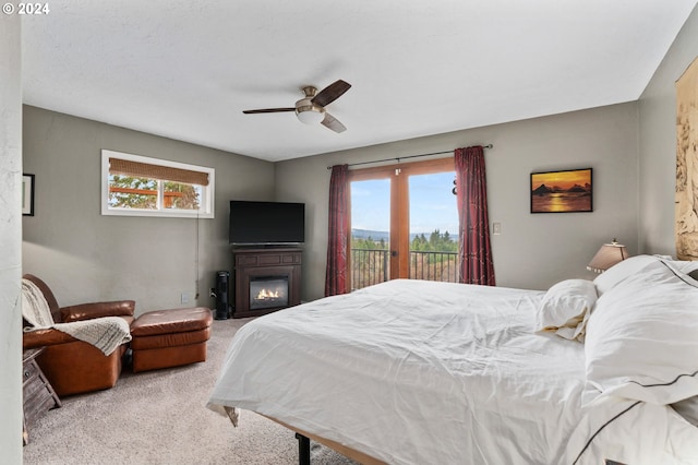 bedroom featuring light carpet, access to outside, multiple windows, and ceiling fan