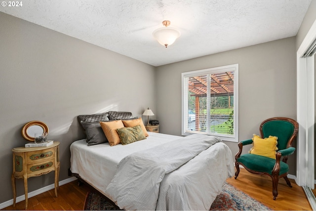 bedroom with wood-type flooring and a textured ceiling