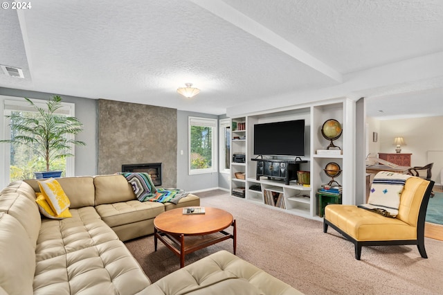 carpeted living room featuring a large fireplace and a textured ceiling