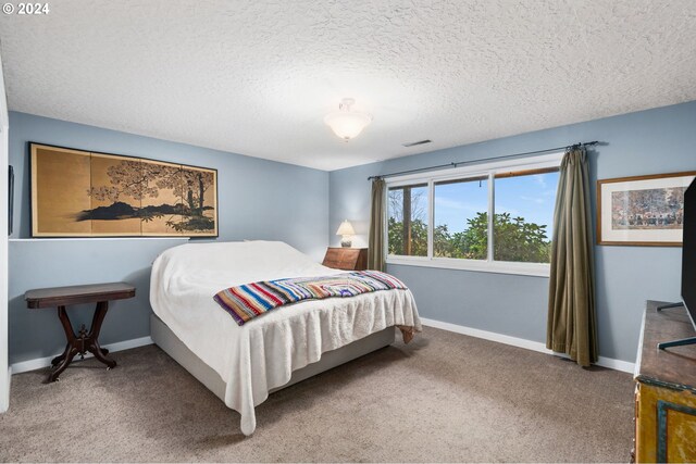 bedroom featuring a textured ceiling and carpet floors