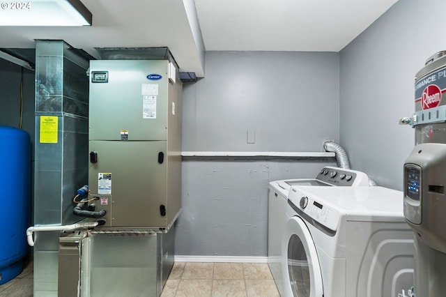 clothes washing area with light tile patterned flooring, independent washer and dryer, and heating unit