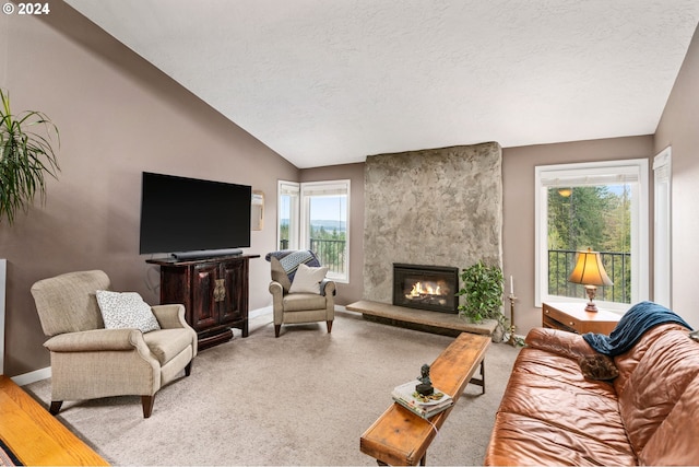 living room with a fireplace, a textured ceiling, a wealth of natural light, and lofted ceiling