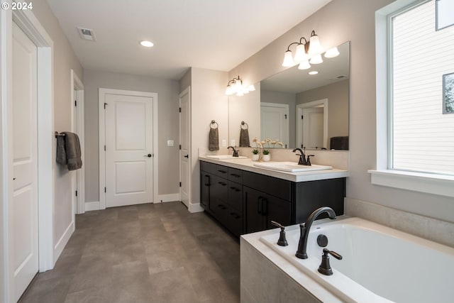 bathroom with vanity and tiled tub