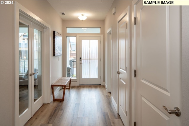 doorway to outside with a wealth of natural light, french doors, and light hardwood / wood-style floors