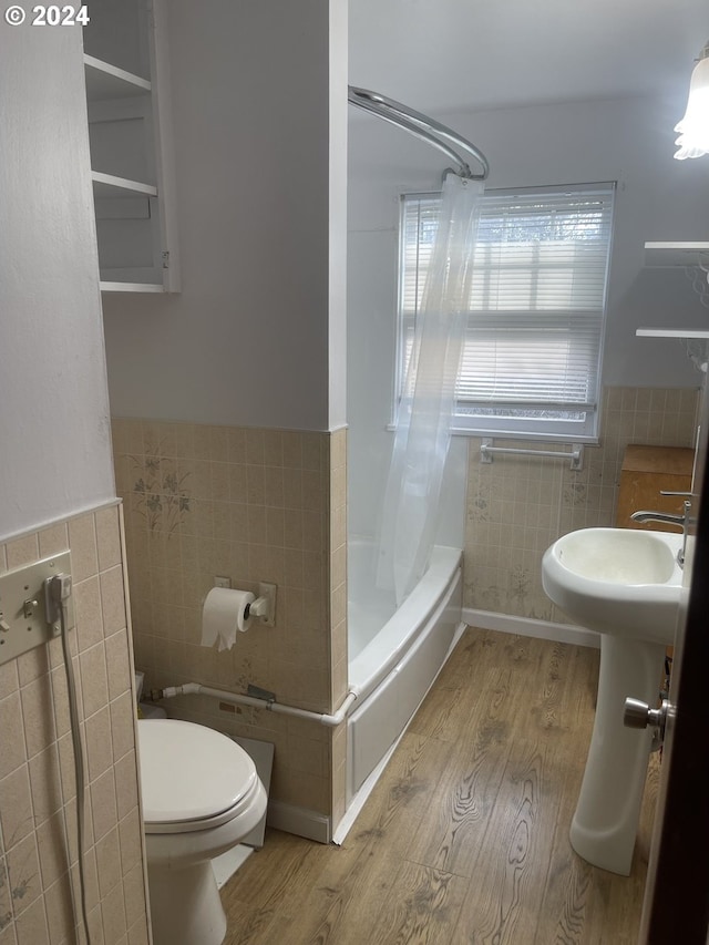 240 N Court St, Heppner, OR 97836 - bathroom featuring tile walls, wood finished floors, toilet, a wainscoted wall, and shower / tub combo with curtain