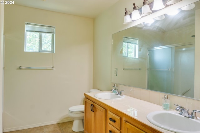 bathroom with a shower with door, vanity, a healthy amount of sunlight, and toilet