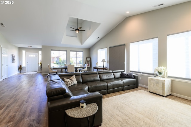 living room featuring lofted ceiling, wood finished floors, visible vents, and baseboards