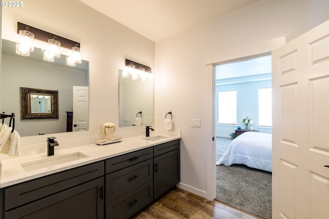 bathroom featuring double vanity, wood finished floors, ensuite bathroom, and a sink