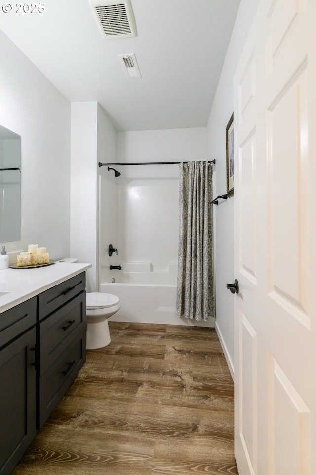 full bathroom with visible vents, shower / bathtub combination with curtain, wood finished floors, and vanity