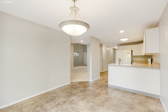 kitchen with decorative light fixtures, white cabinetry, white refrigerator with ice dispenser, range, and kitchen peninsula