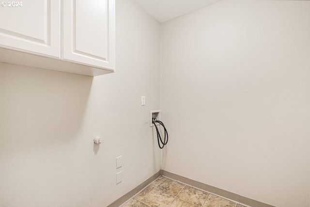 clothes washing area featuring hookup for a washing machine and cabinets